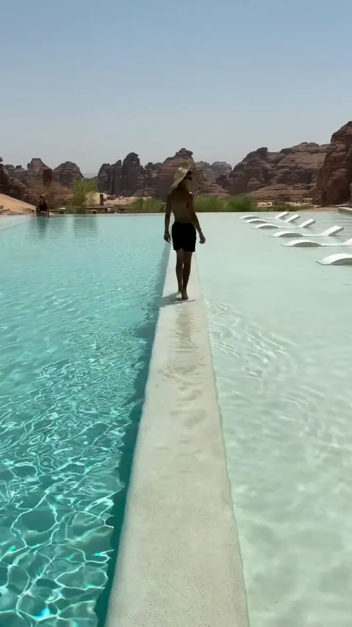 A guest walking between infinity pools at Habitas AlUla