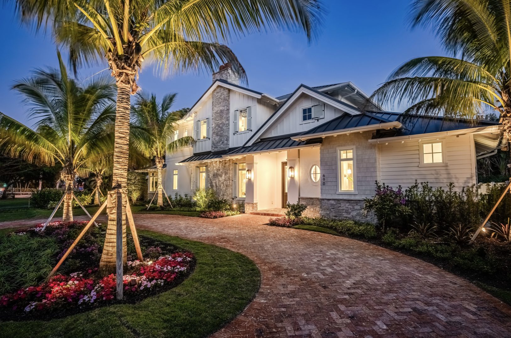 Old Naples Transitional at dusk, brick drive and palms