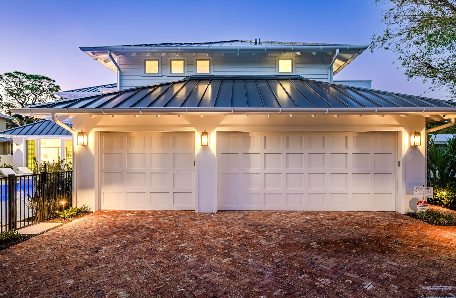 Old Naples Transitional garage court lit at dusk